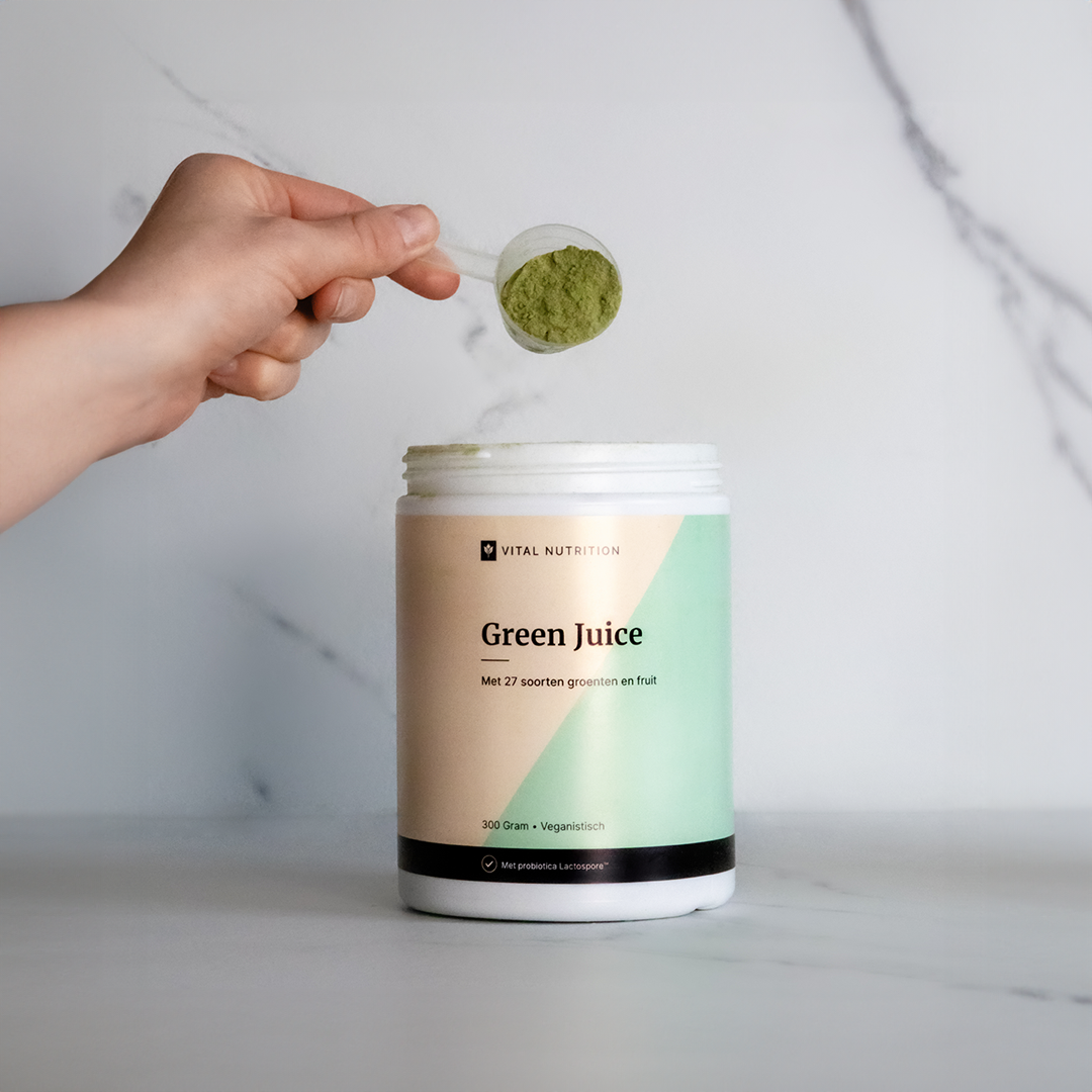 Vital Nutrition Green Juice met hand die schepje met poeder vasthoudt