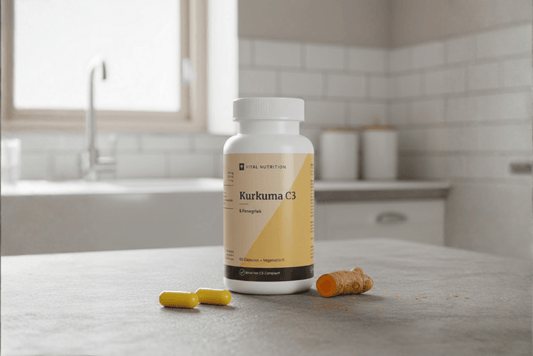 Kurkuma C3 van Vital Nutrition op keukenaanrecht met twee capsules en stukje rauwe kurkuma