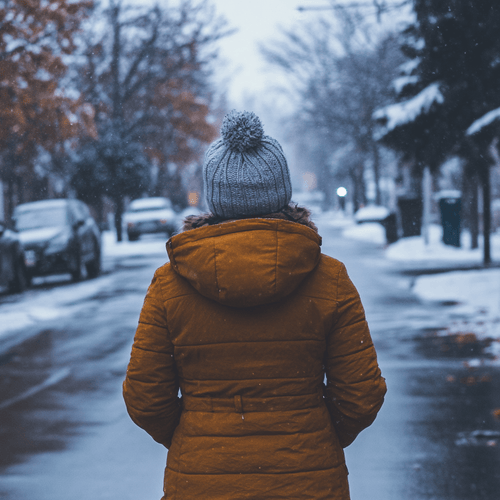 Vrouw loopt buiten in winterse en donkere omgeving 