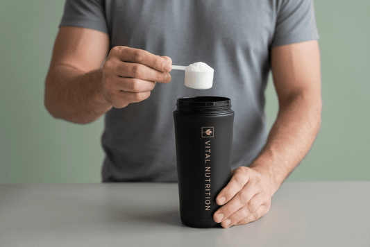 Man schept creatine dosering in Vital Nutrition RVS shaker