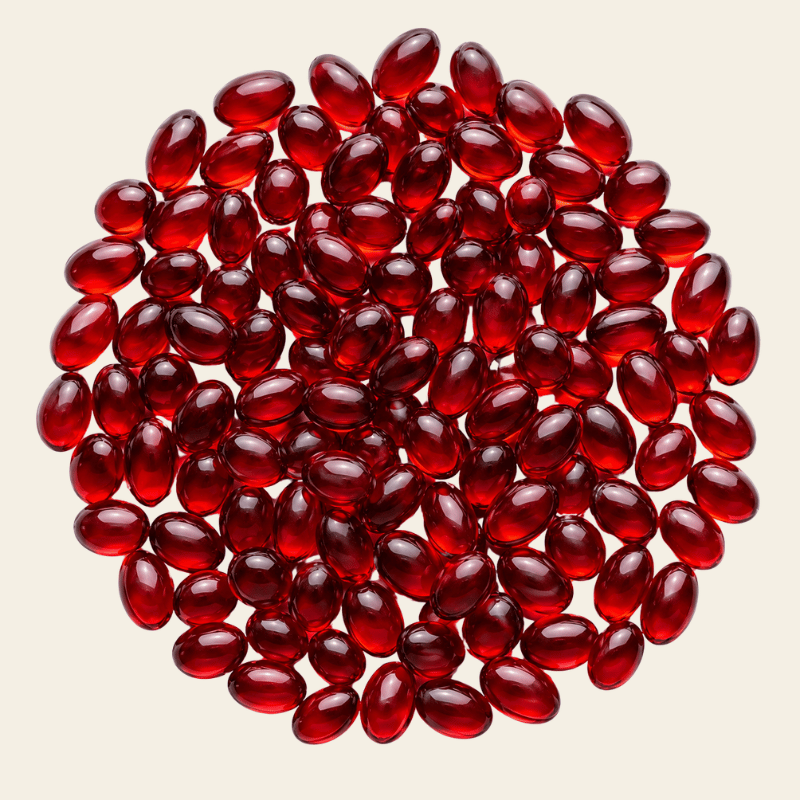 Kleine ovale robijnrode krillolie softgels in een ronde compositie