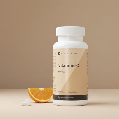 Vitamine C 500 mg van Vital Nutrition op een beige minimalistische studio ondergrond met 2 tabletten en schijfje sinaasappel op de voorgrond