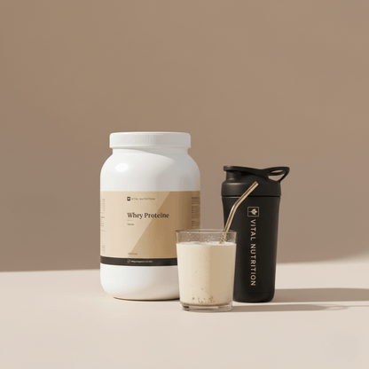 Whey Proteïne van Vital Nutrition op een beige minimalistische studio ondergrond met de Vital Shaker en een gevuld glas met een shake erin op de voorgrond
